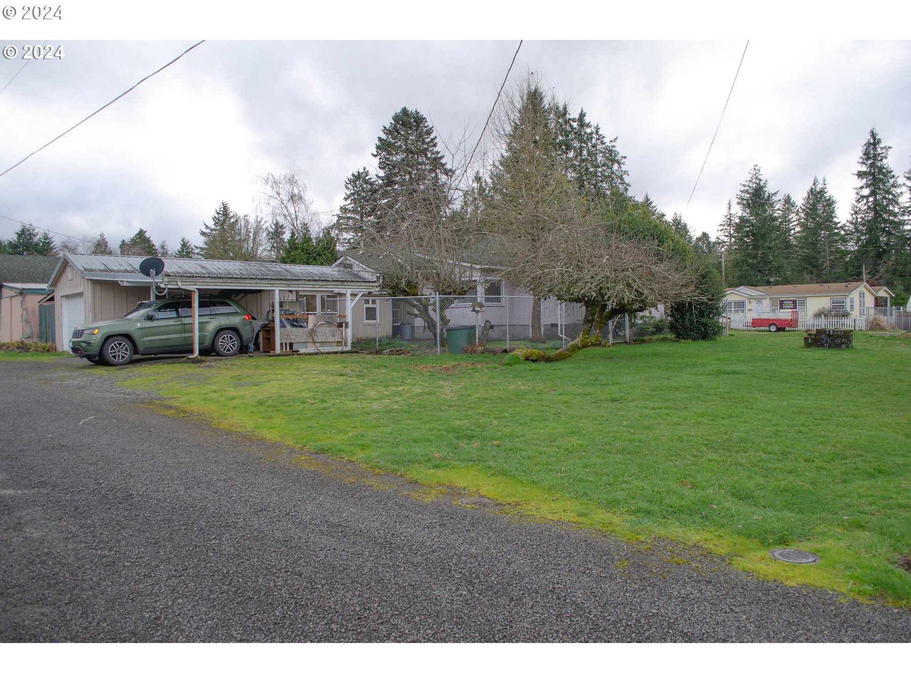 a view of a house with a big yard and large trees