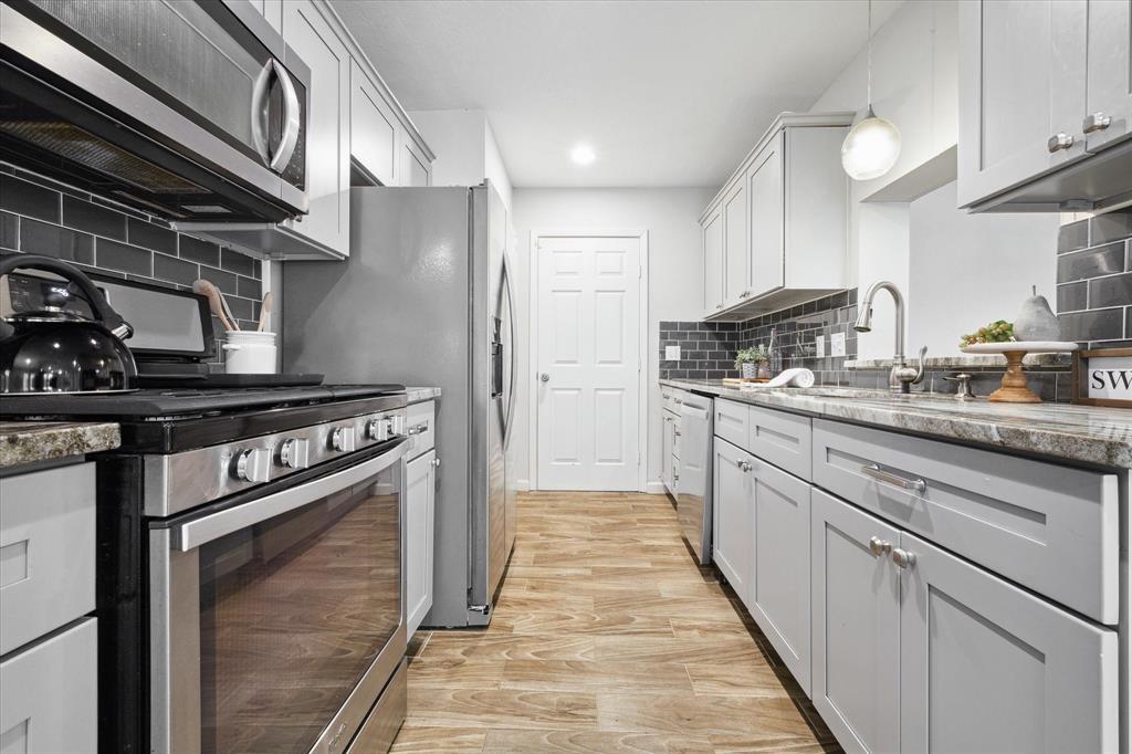 a kitchen with stainless steel appliances granite countertop a stove and a sink