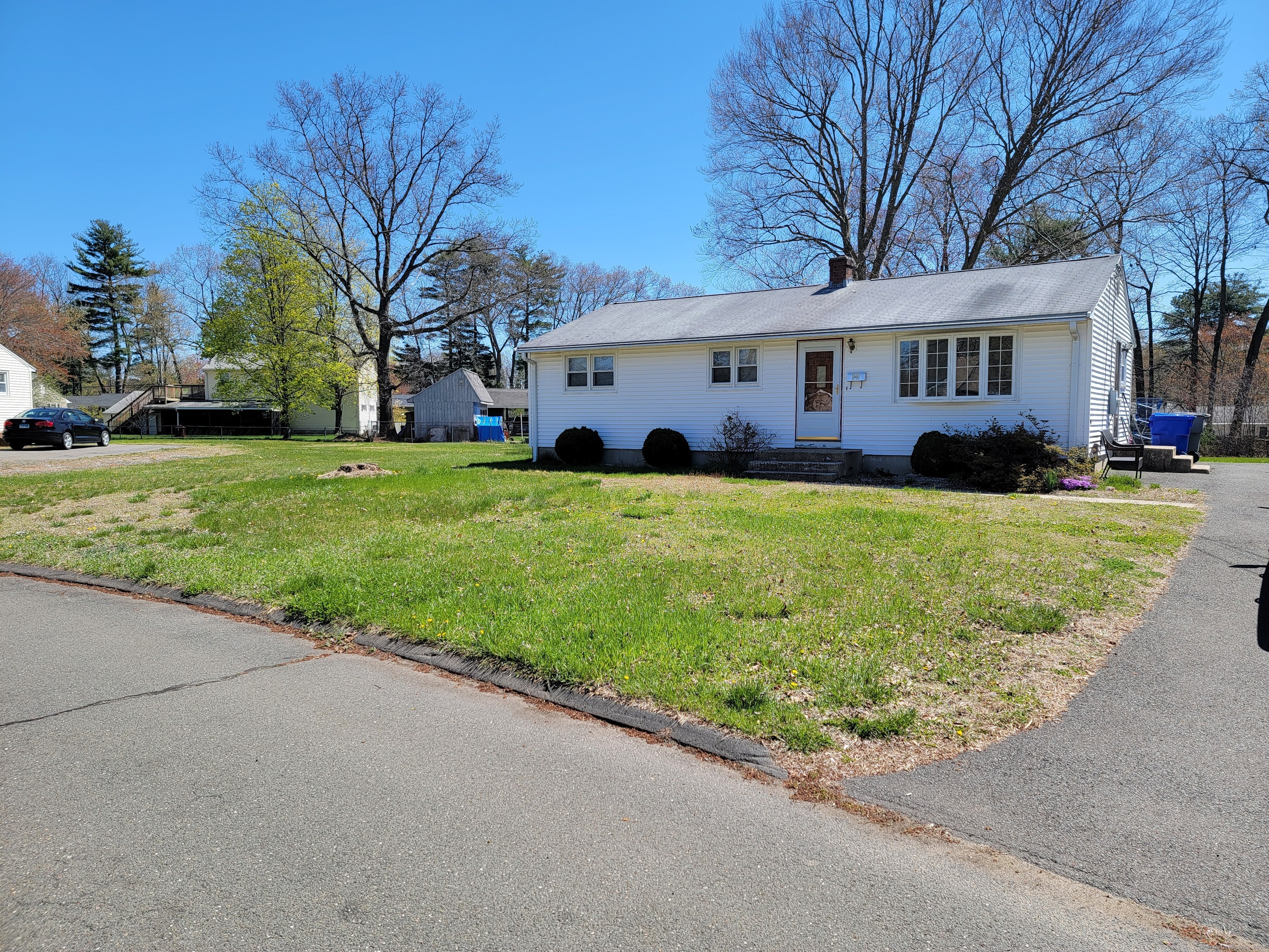 a front view of a house with a garden and trees