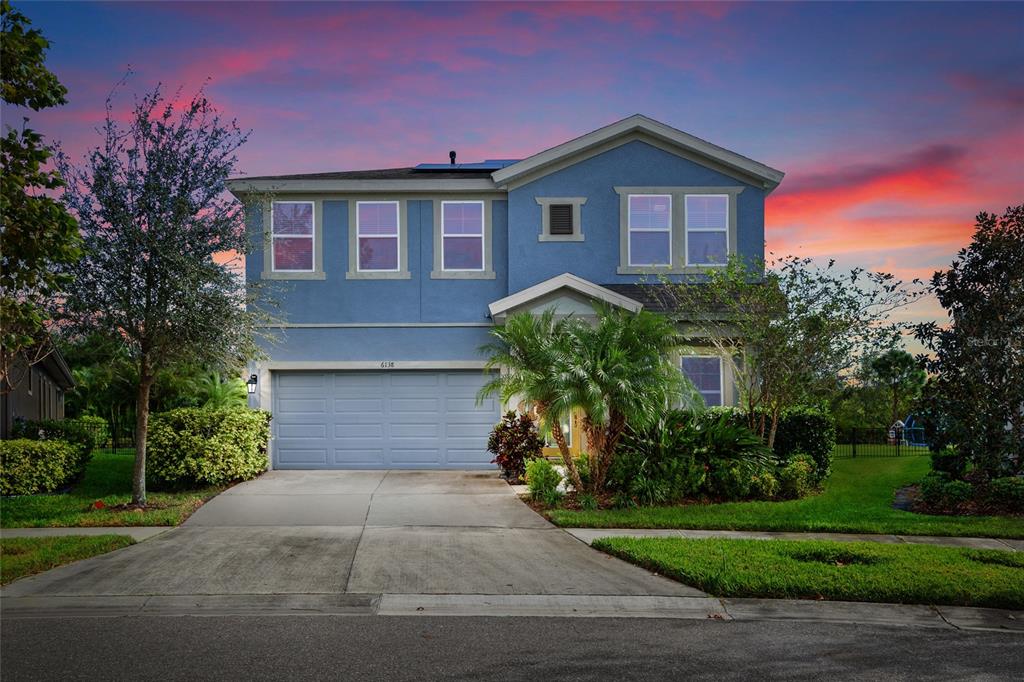 a front view of a house with a yard and a garage