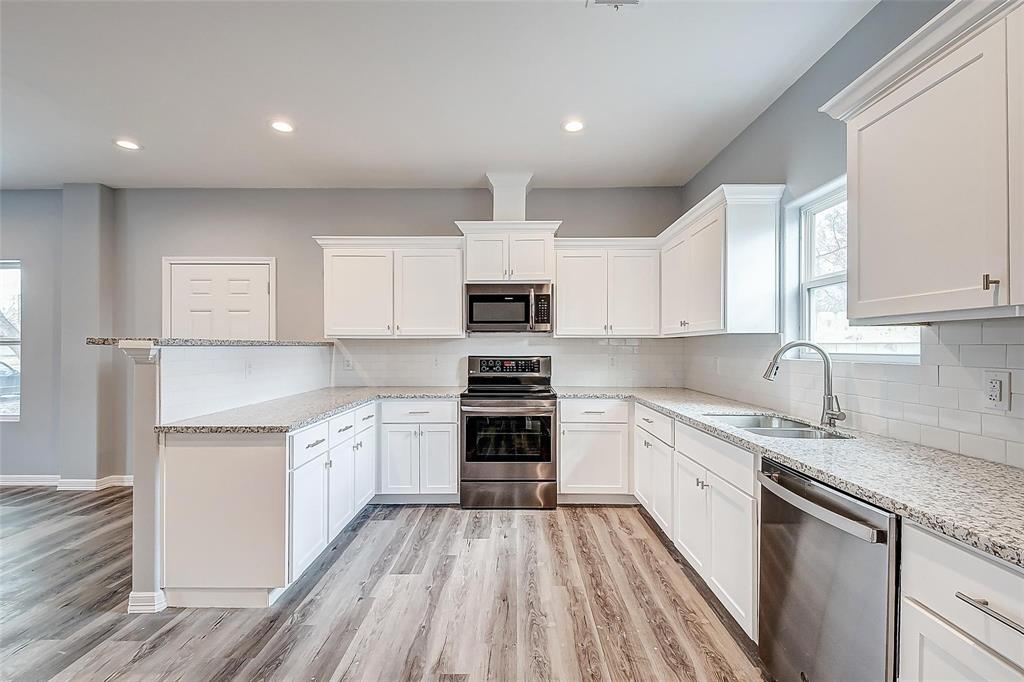 a kitchen with granite countertop white cabinets and white appliances