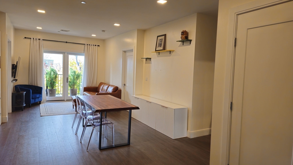 a view of a hallway with furniture and wooden floor