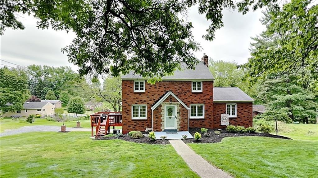 a view of a house with a big yard plants and large trees