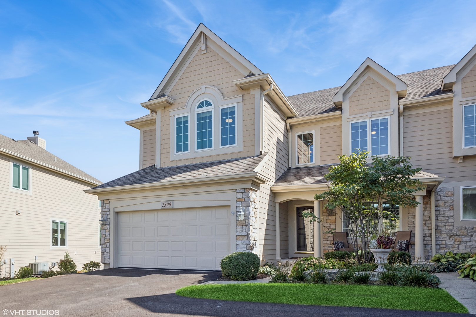 a front view of a house with a garden and garage