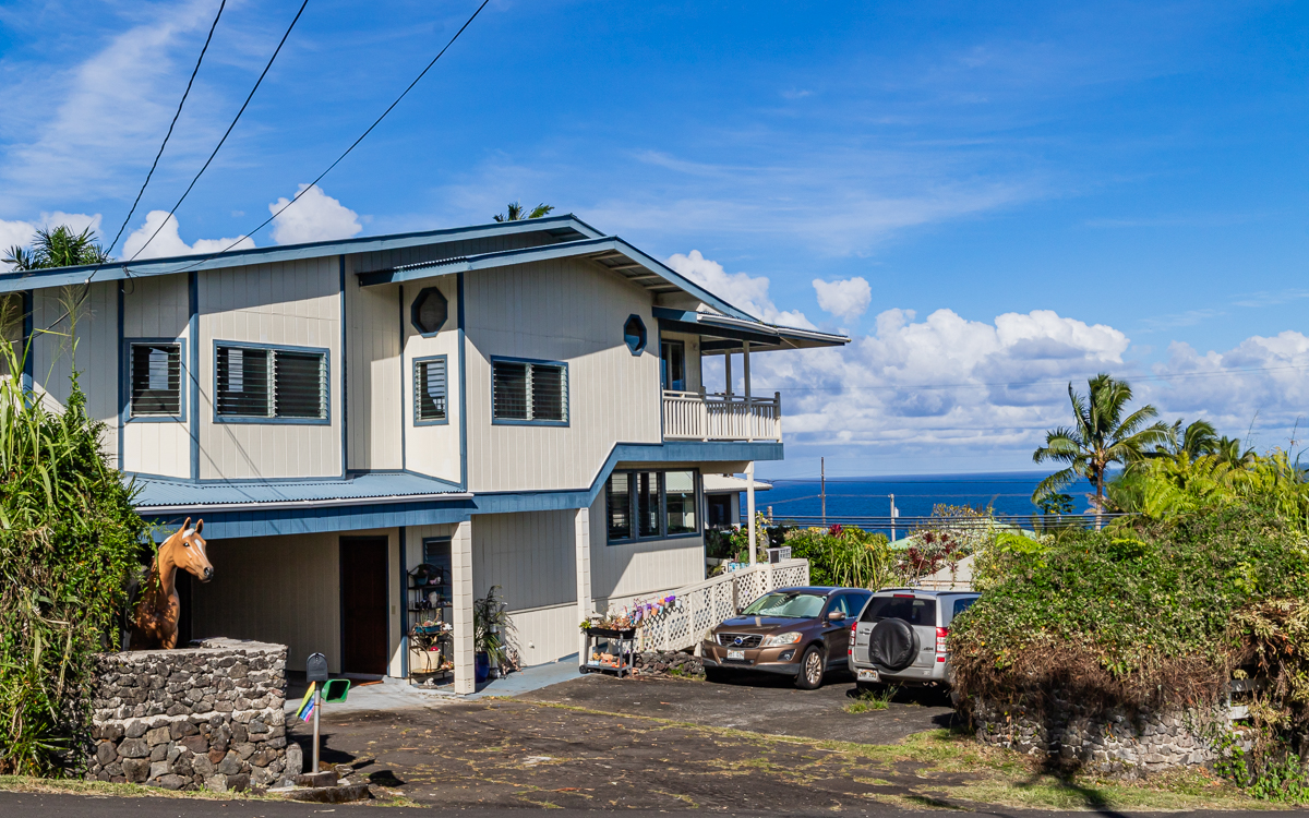 a front view of a house with a yard and seating space