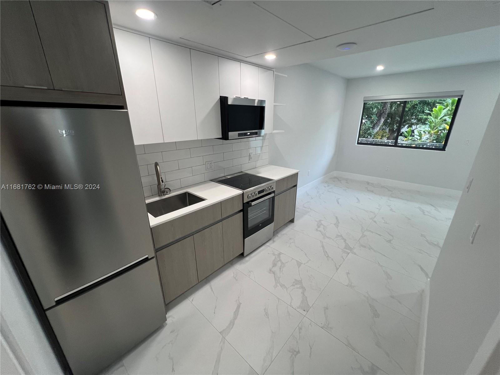 a kitchen with stainless steel appliances granite countertop a refrigerator and a microwave