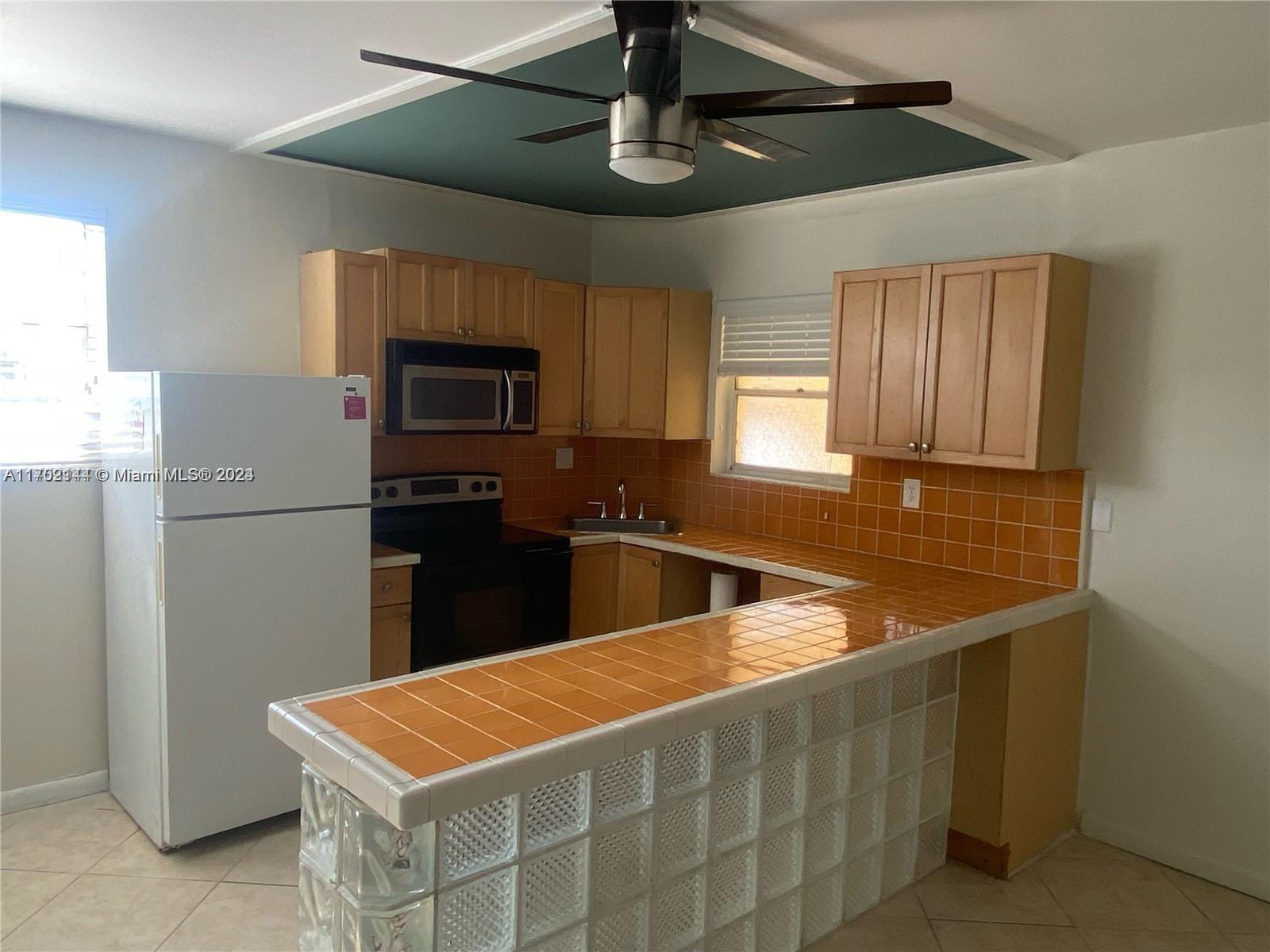 a kitchen with stainless steel appliances granite countertop a sink a refrigerator and a stove