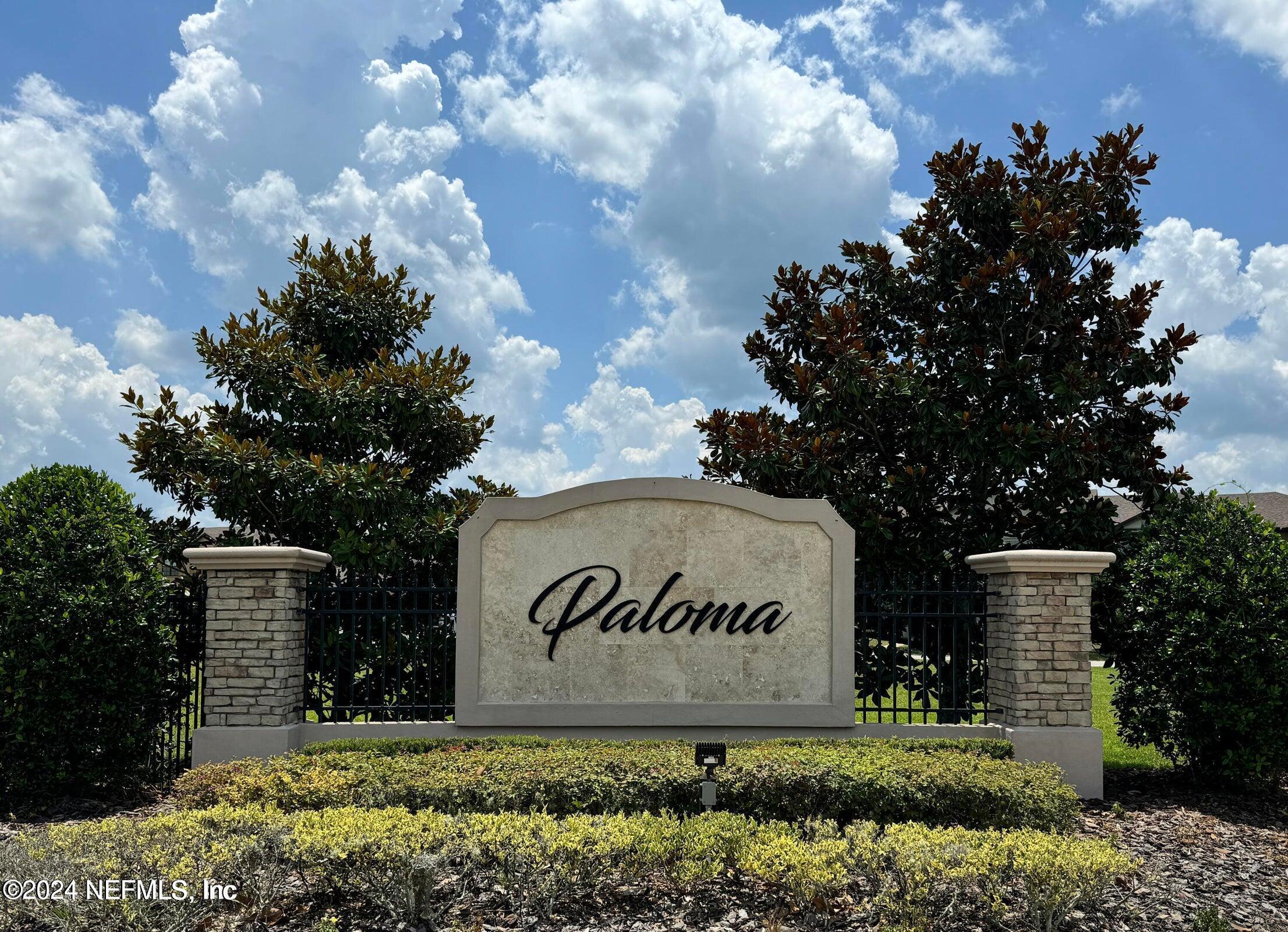 a sign board with a house in the background