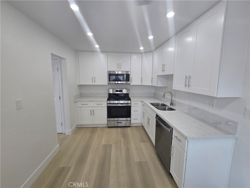 a kitchen with a sink a stove top oven and cabinets