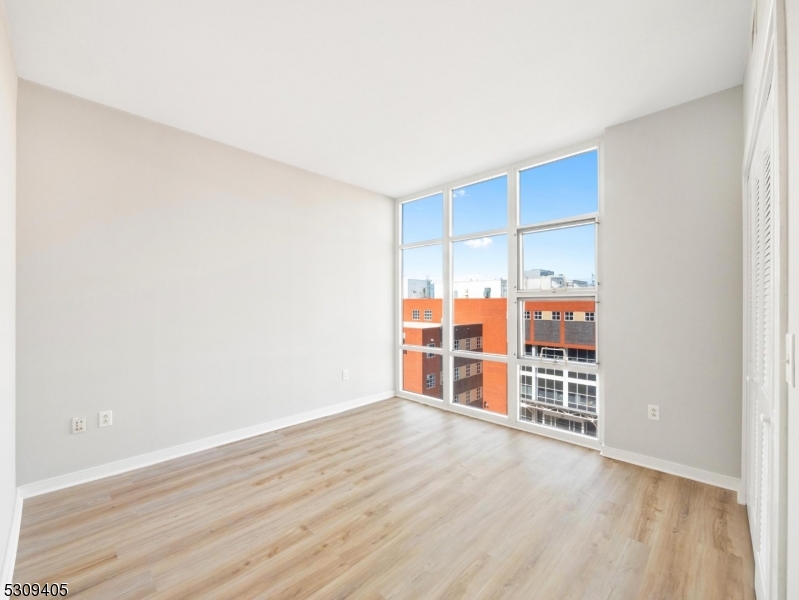 an empty room with wooden floor and closet