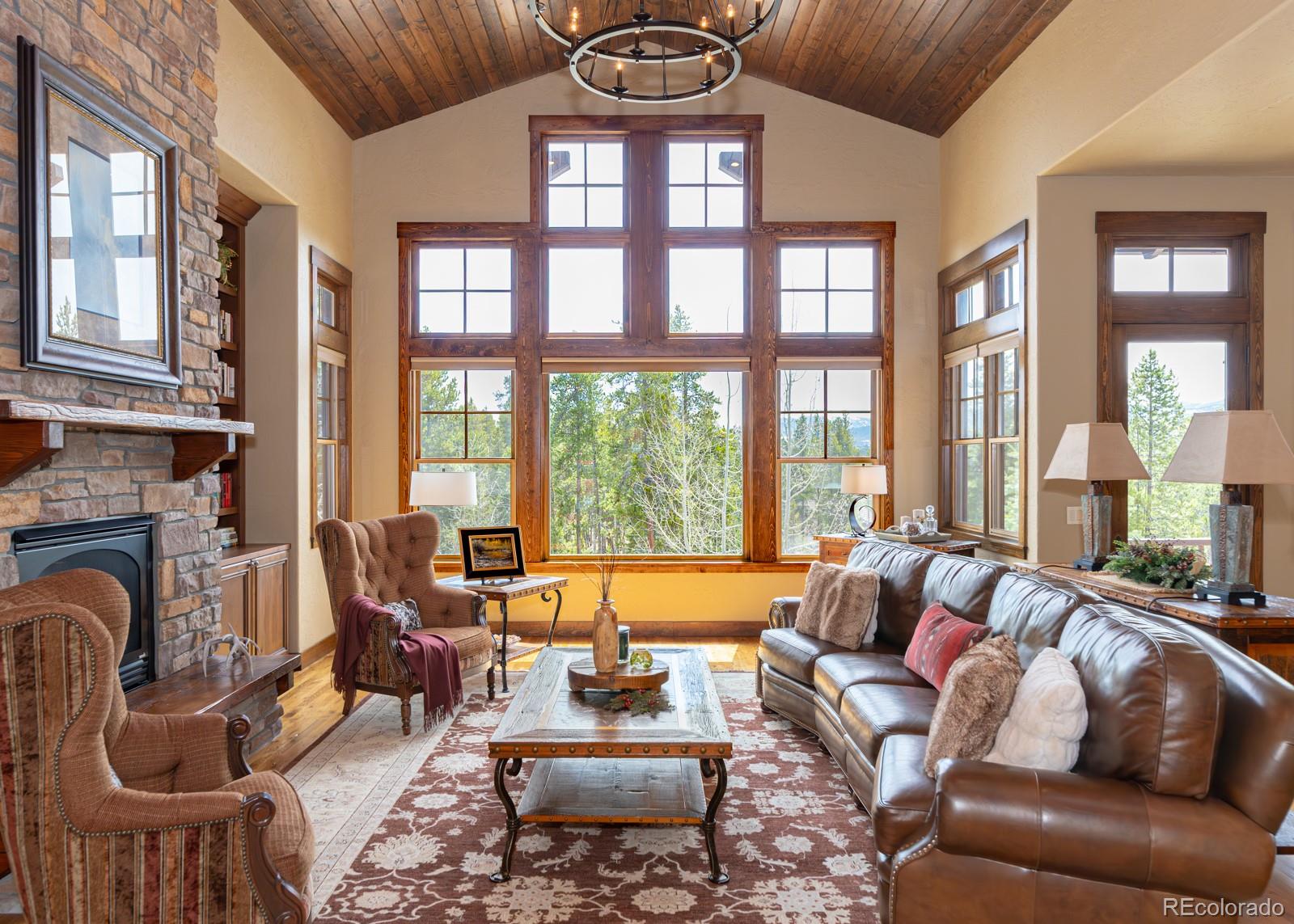 a living room with furniture a fireplace and large windows