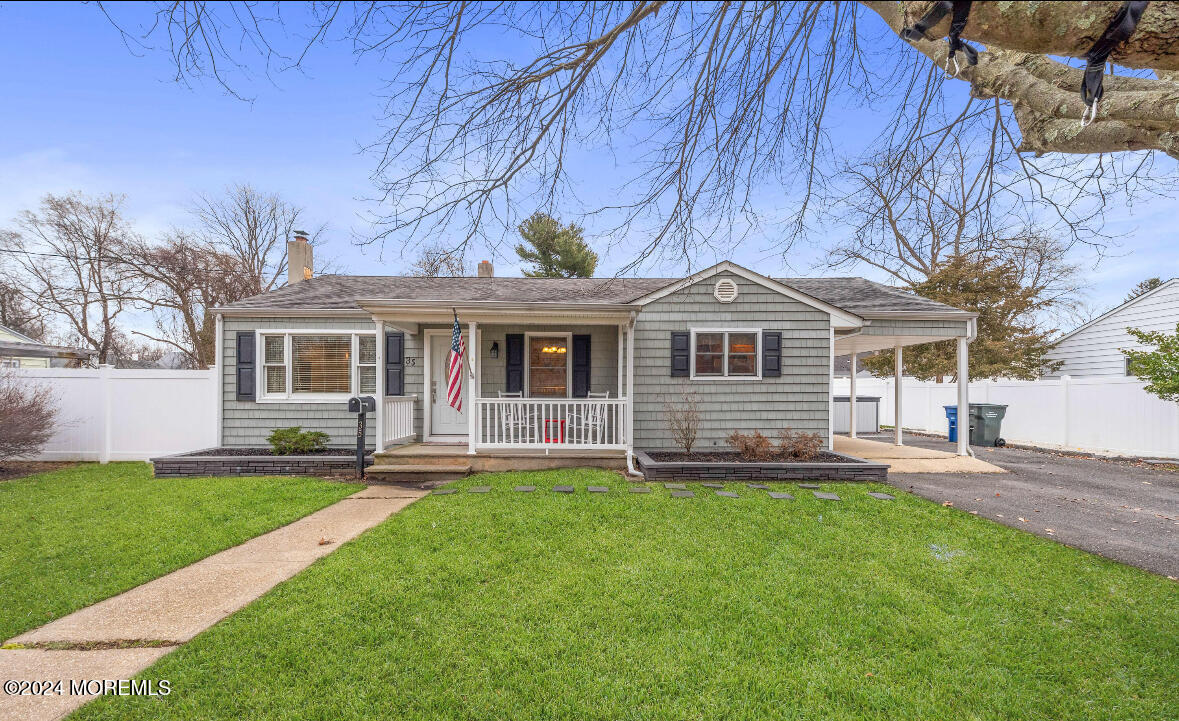 a front view of a house with a yard and trees