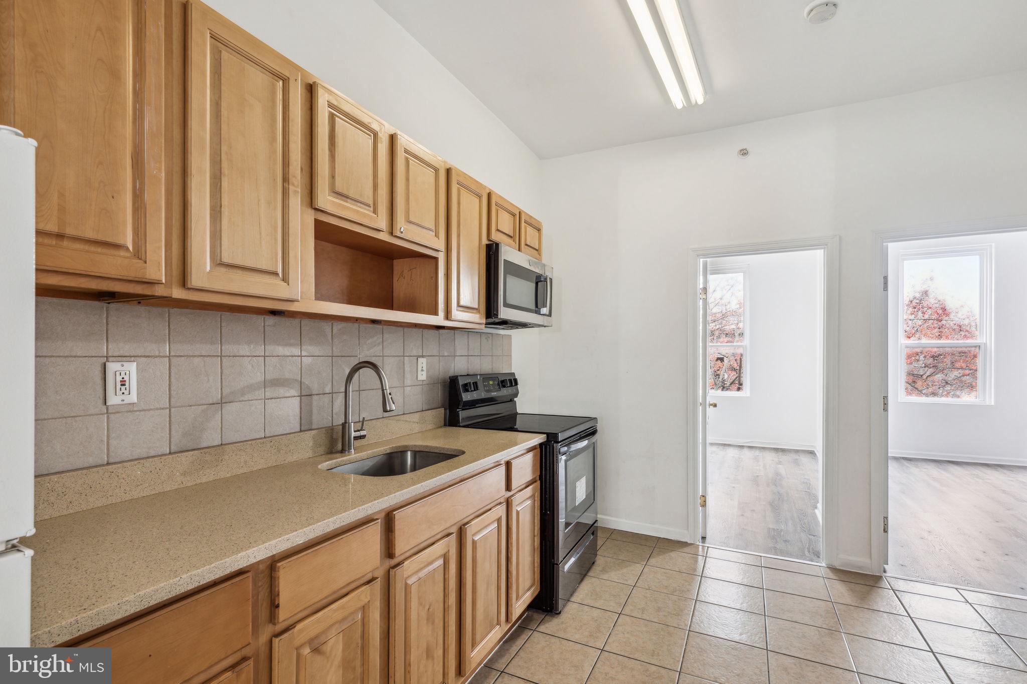 a kitchen with stainless steel appliances granite countertop a sink stove and cabinets