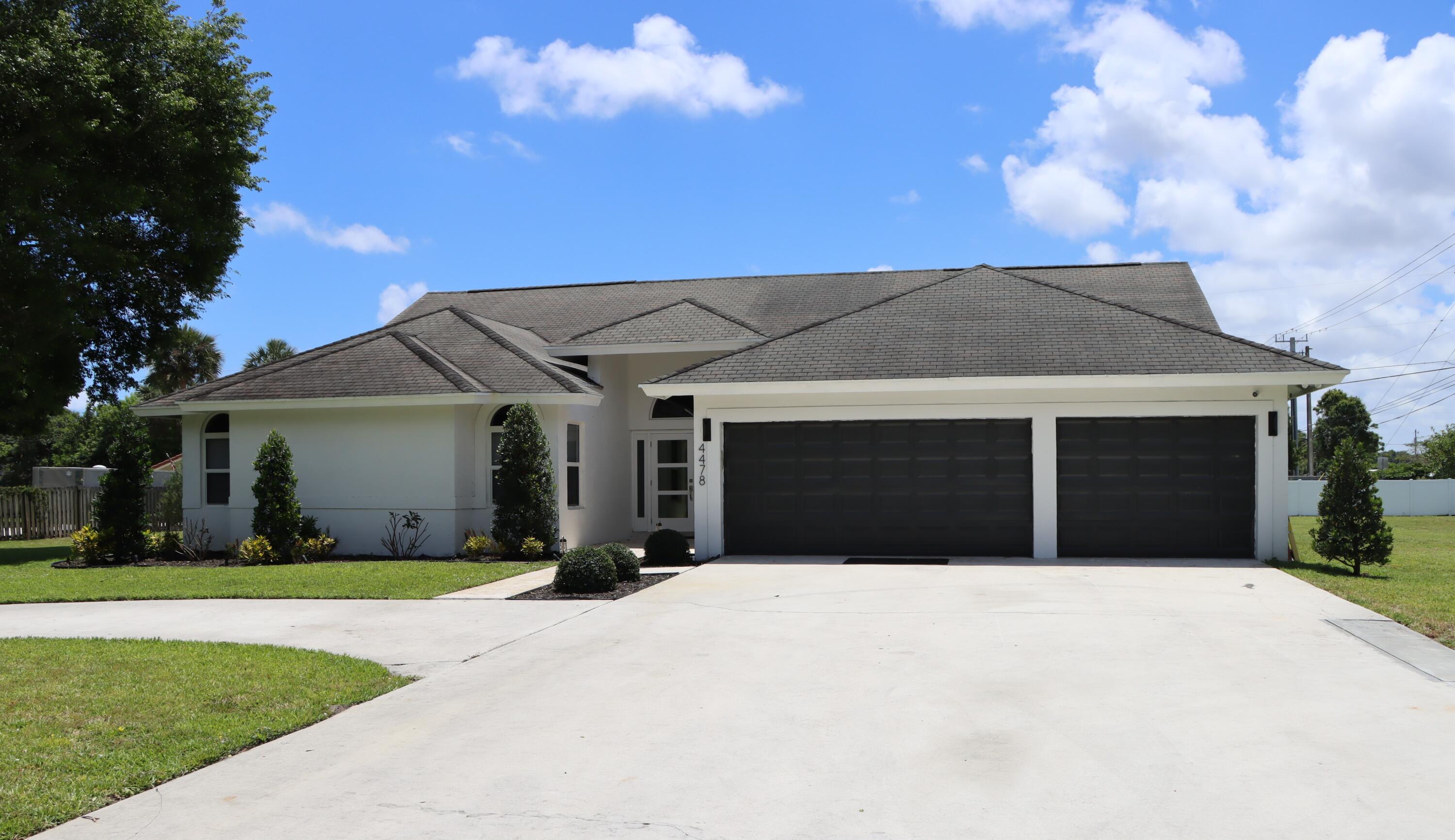 a front view of house with yard and garage