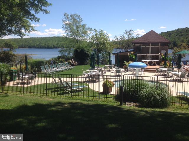 a front view of a house with a garden and lake view