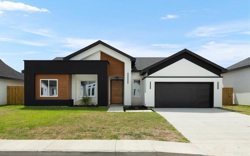 View of front of house featuring a front yard and a garage