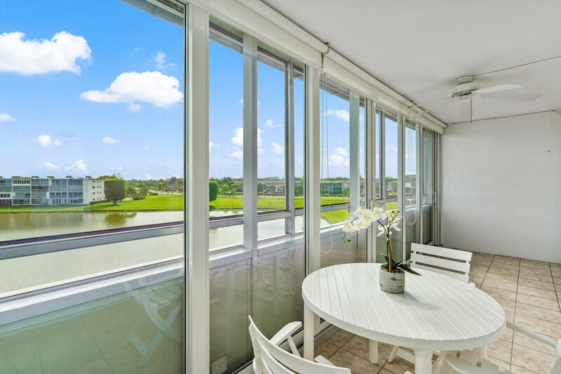 a dining room with furniture and a floor to ceiling window