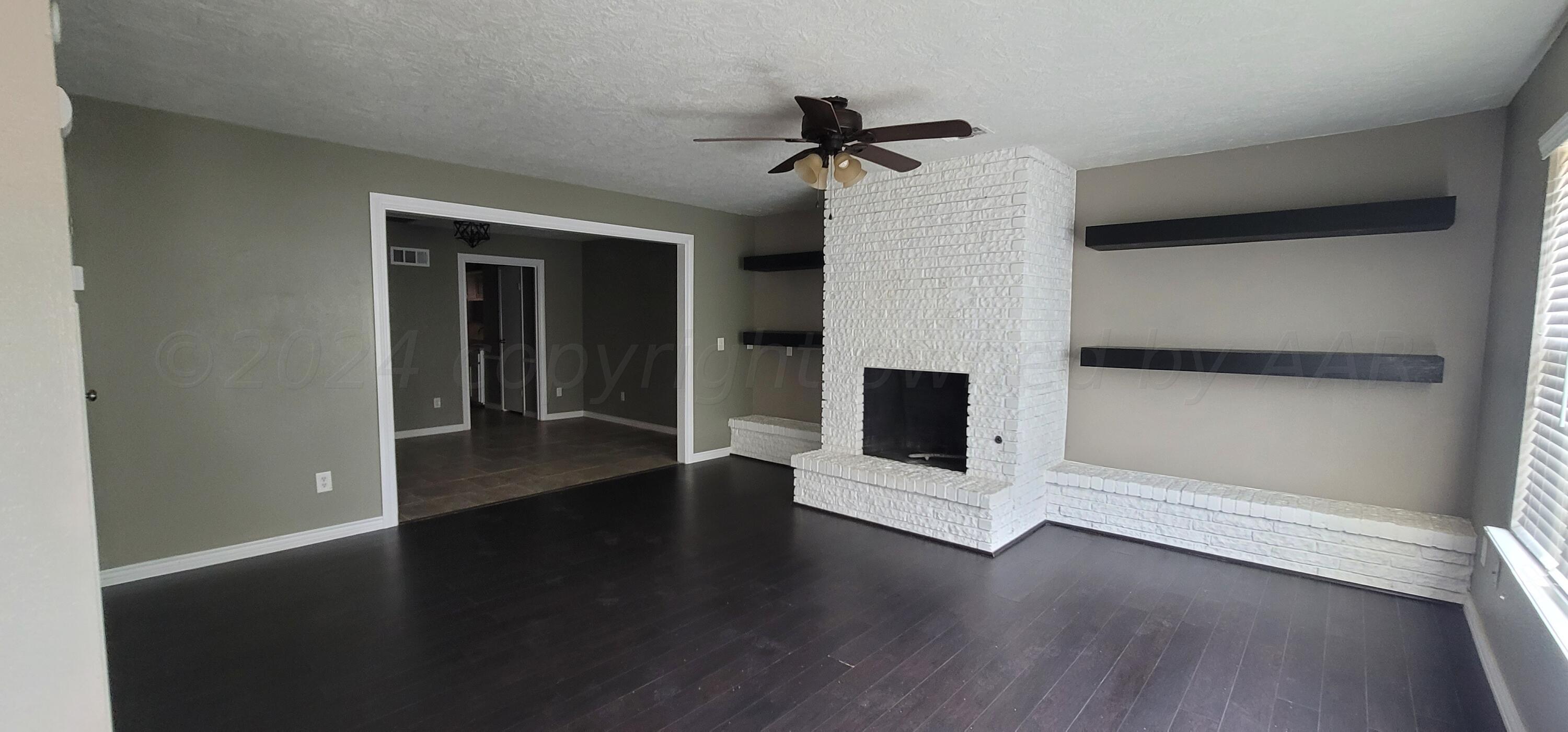 a view of a livingroom with wooden floor and a ceiling fan