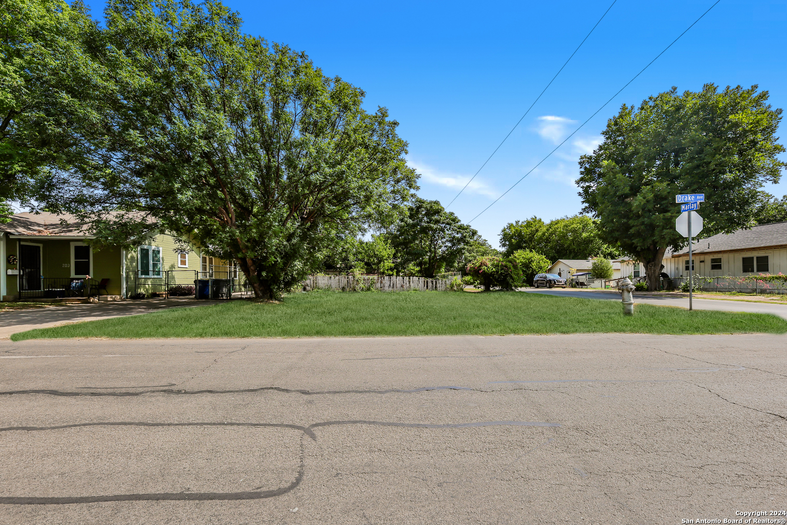 a view of a house with a big yard and large trees