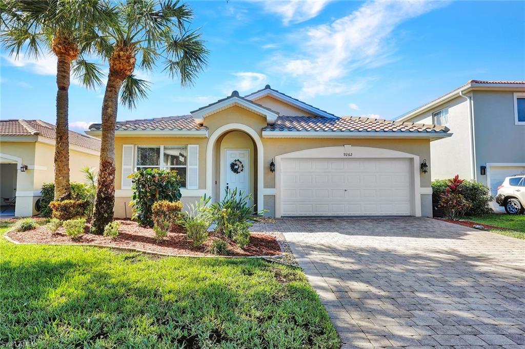 a view of a house with a small yard plants and palm trees