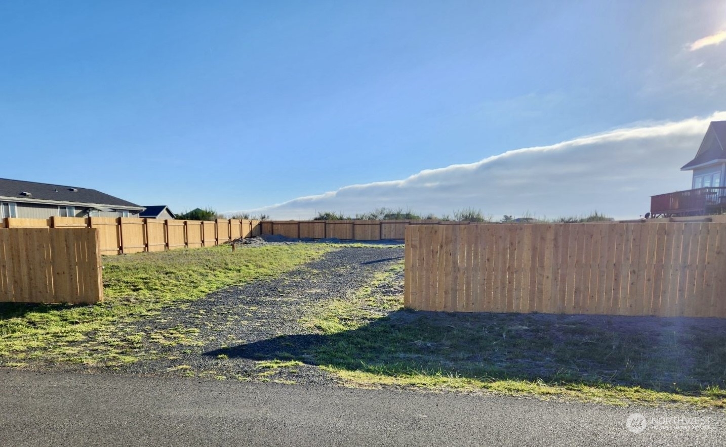 a view of a yard with wooden fence