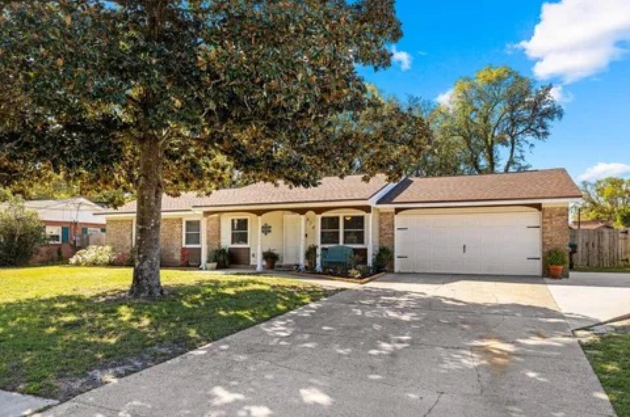 a front view of a house with a yard and trees