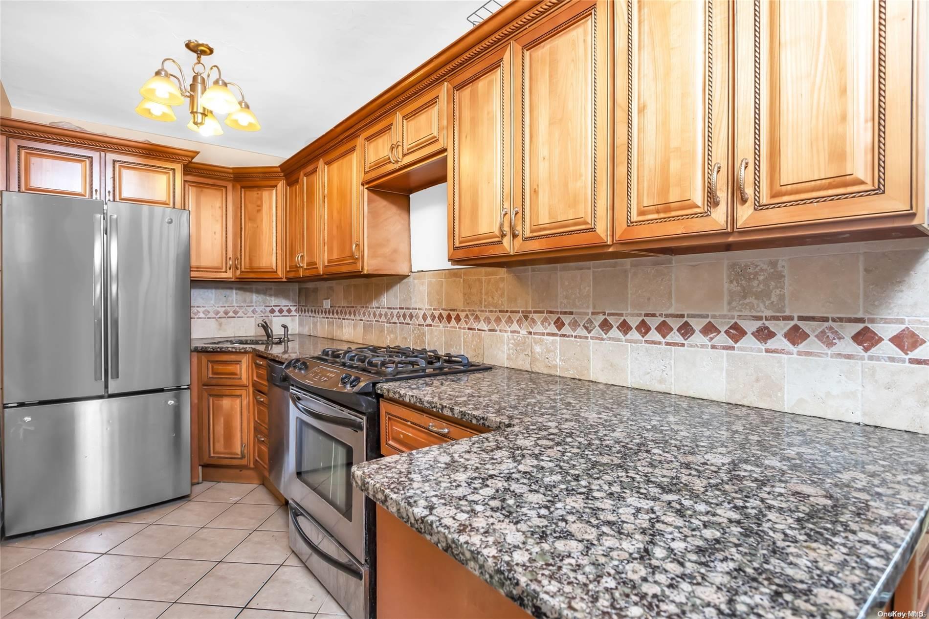 a kitchen with stainless steel appliances granite countertop a refrigerator a stove and a sink