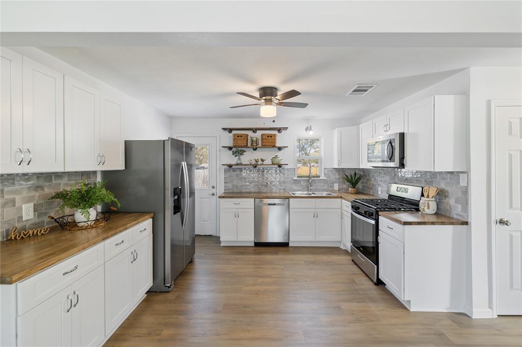 a kitchen with white cabinets and stainless steel appliances