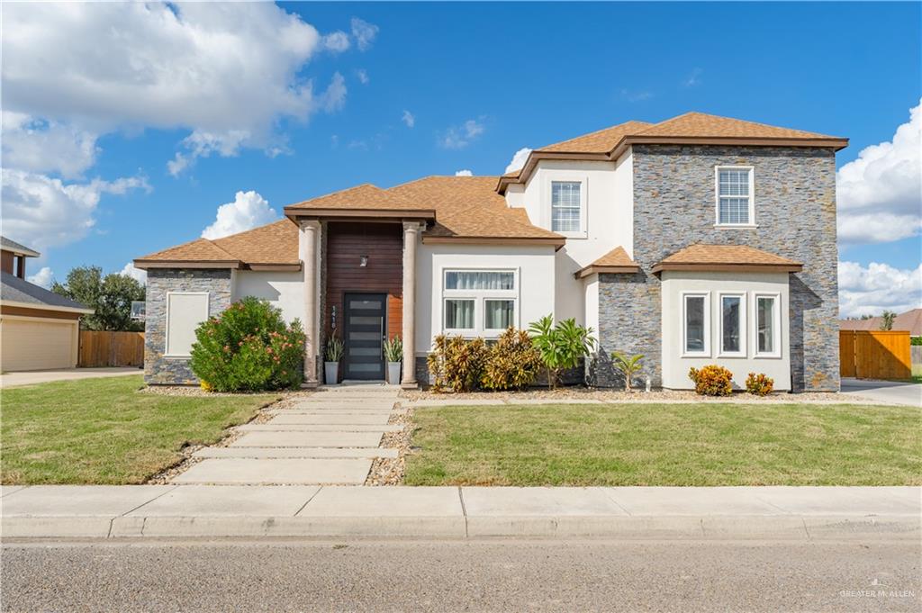 View of front of house featuring a garage and a front lawn