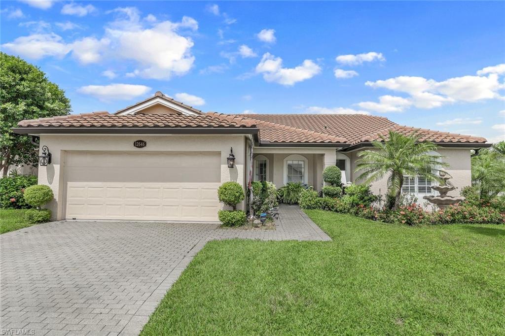 Mediterranean / spanish-style home featuring a front lawn and a garage