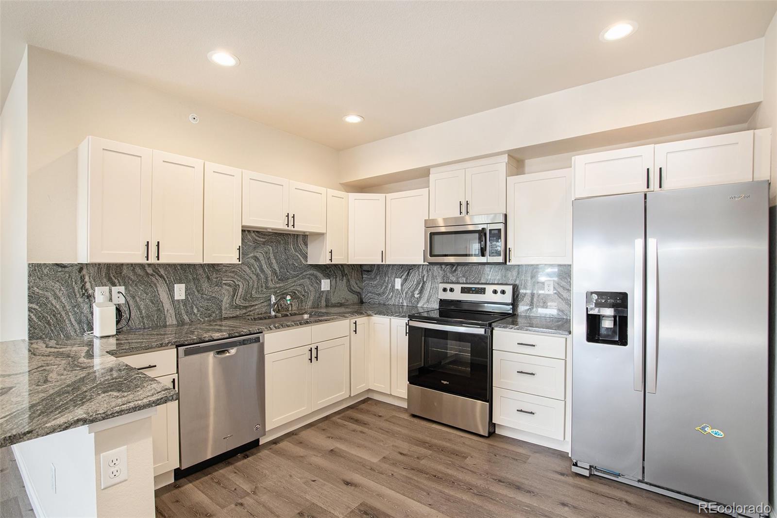 a kitchen with stainless steel appliances kitchen island granite countertop a sink and cabinets