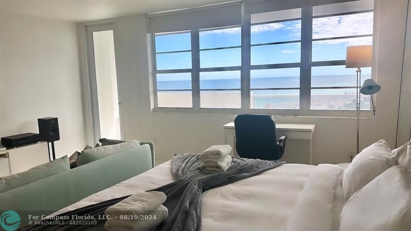 a bedroom with a bed and a large window