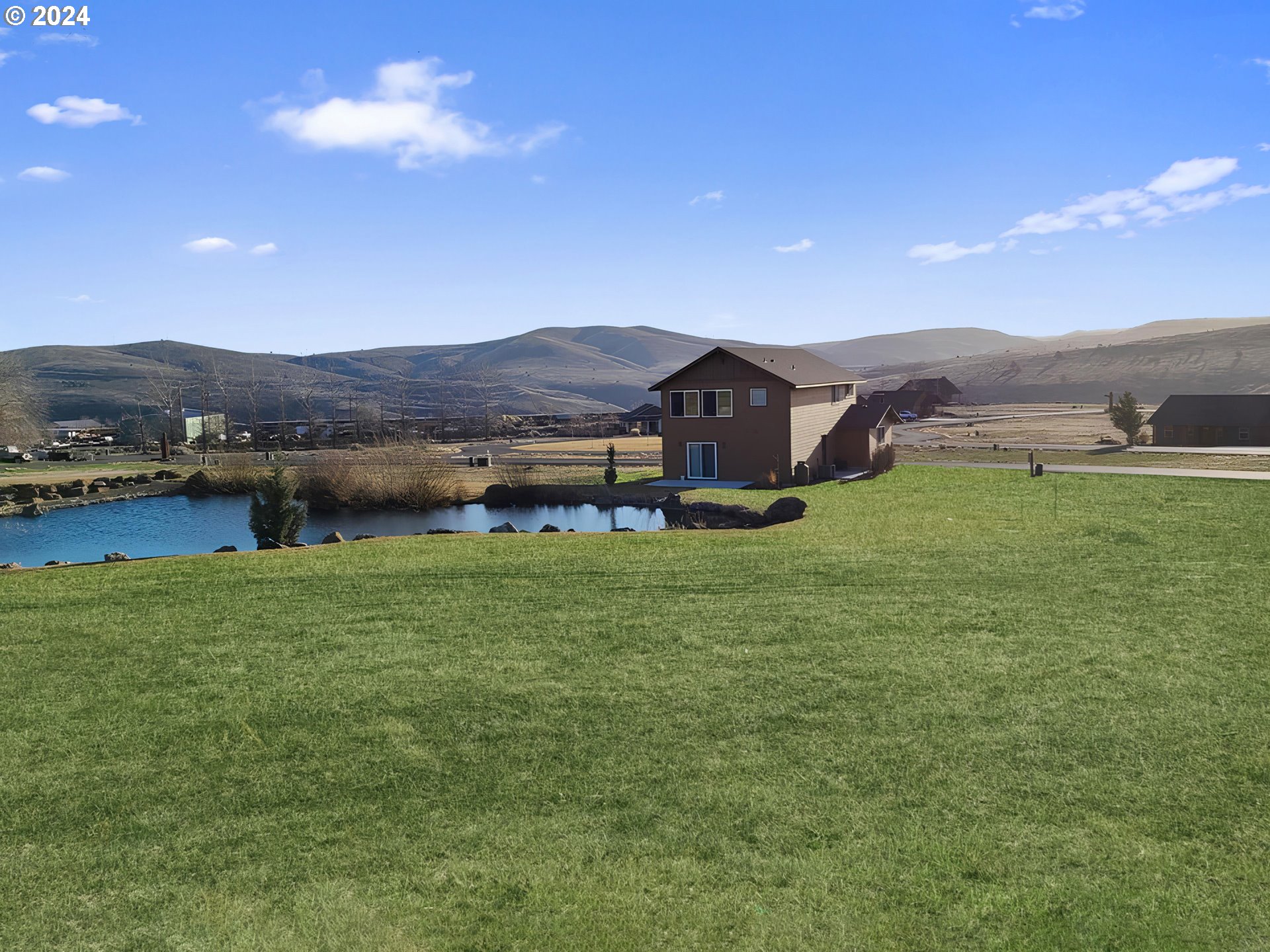 a view of a house with a yard and a lake view