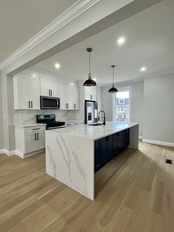 a large kitchen with kitchen island a sink stainless steel appliances and cabinets