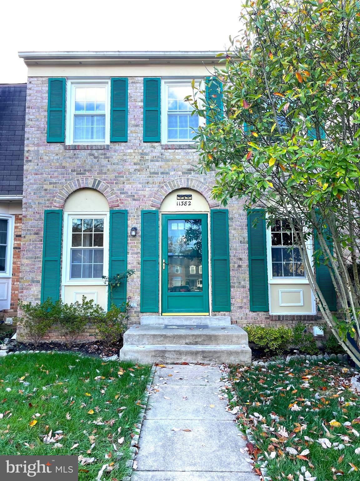 front view of a brick house with a yard