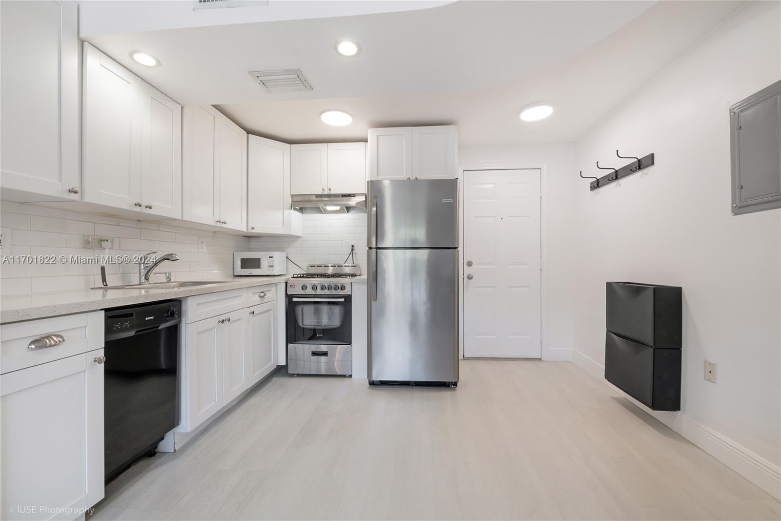 a kitchen with a refrigerator a stove top oven and cabinets