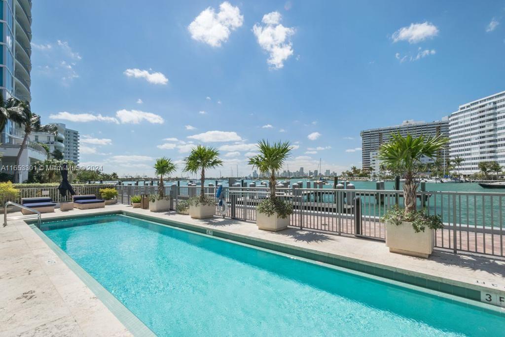 a view of a swimming pool with a patio and lake view