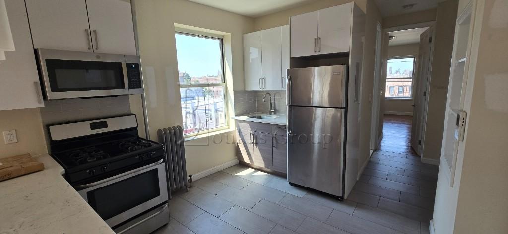 a kitchen with a refrigerator stove and wooden cabinets