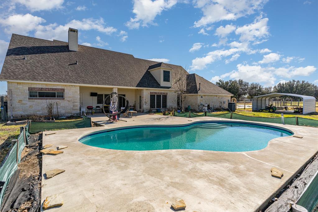 a view of a house with swimming pool and a yard