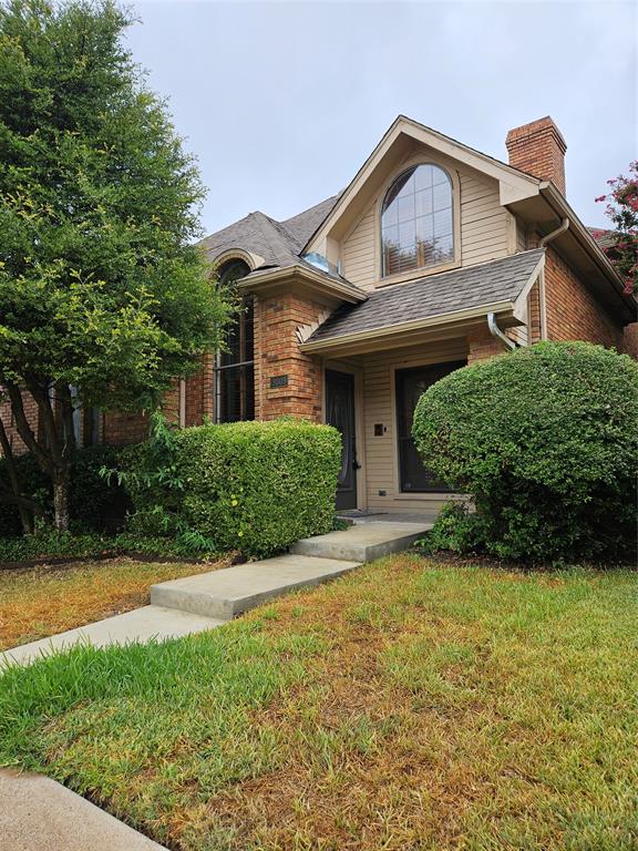 a front view of a house with yard and green space