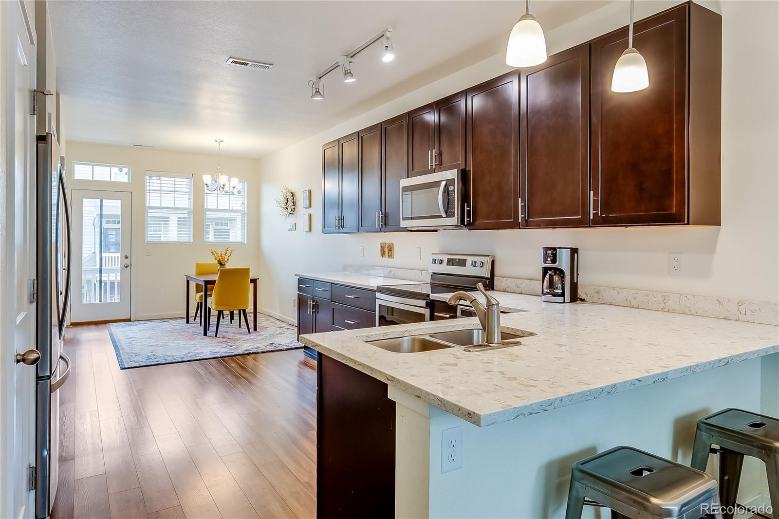 a kitchen with a sink a counter top space and living room view