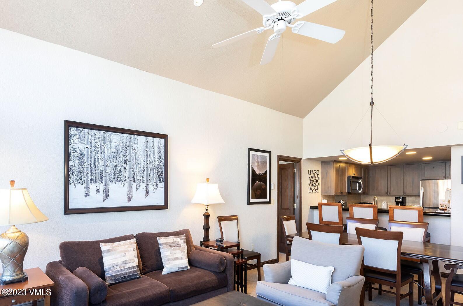 a living room with furniture kitchen view and a chandelier