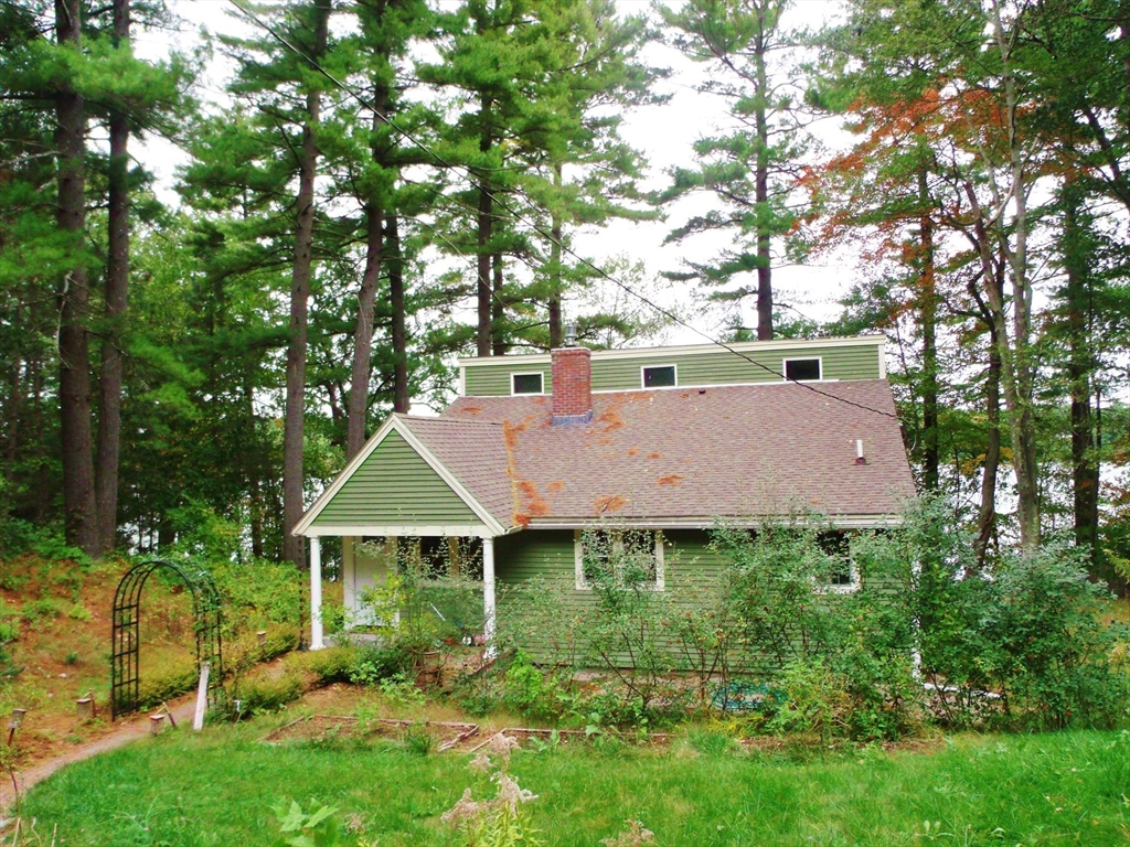 a view of a house with garden and a tree