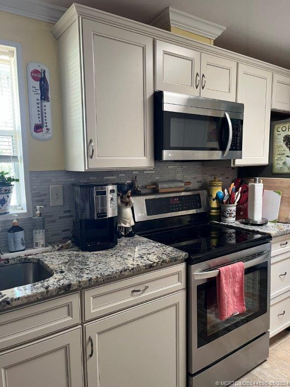 a kitchen with granite countertop a stove a sink and a microwave