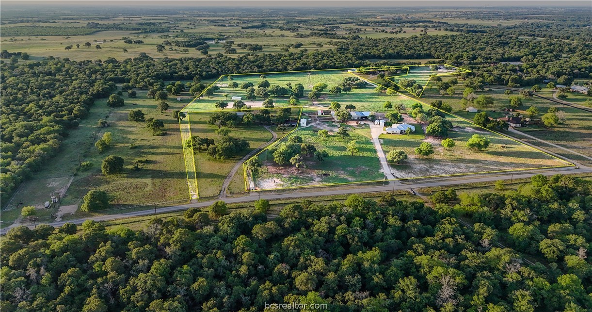 an aerial view of residential houses with outdoor space and trees