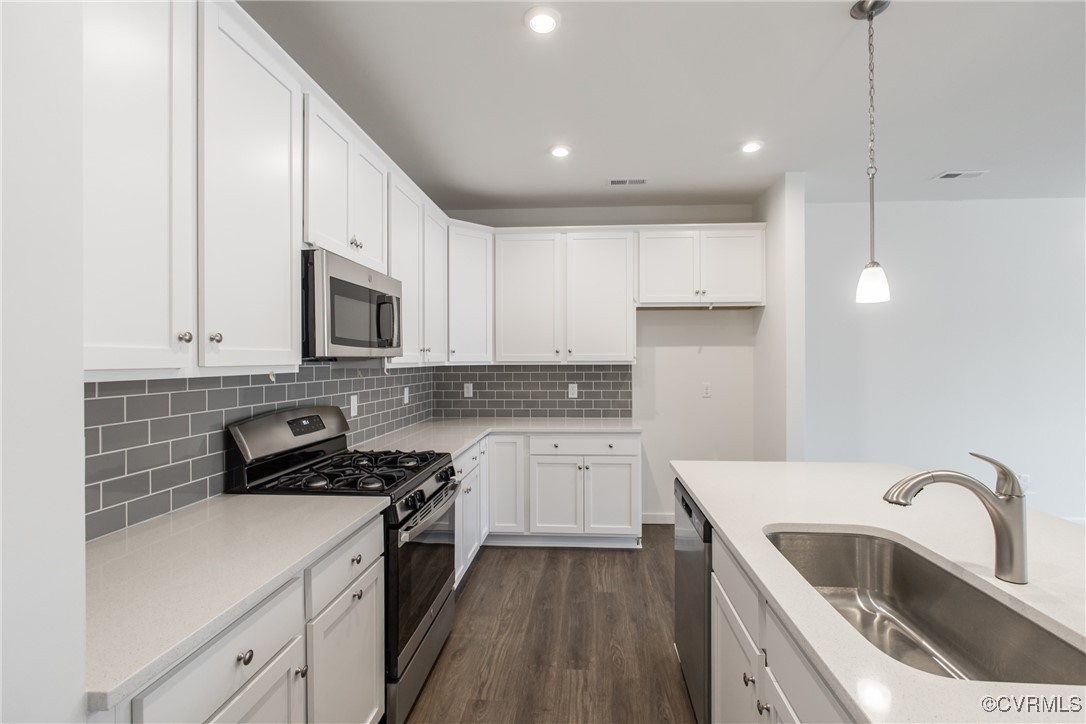 a kitchen with a sink stove top oven and cabinets