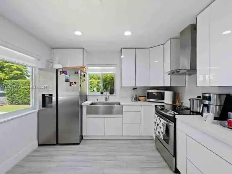 a kitchen with stainless steel appliances a refrigerator sink and cabinets