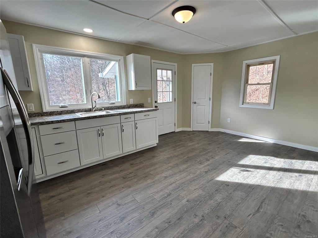 a spacious bathroom with a granite countertop sink and a large mirror