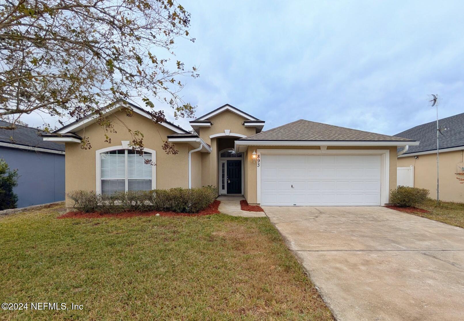 a front view of a house with a yard and garage