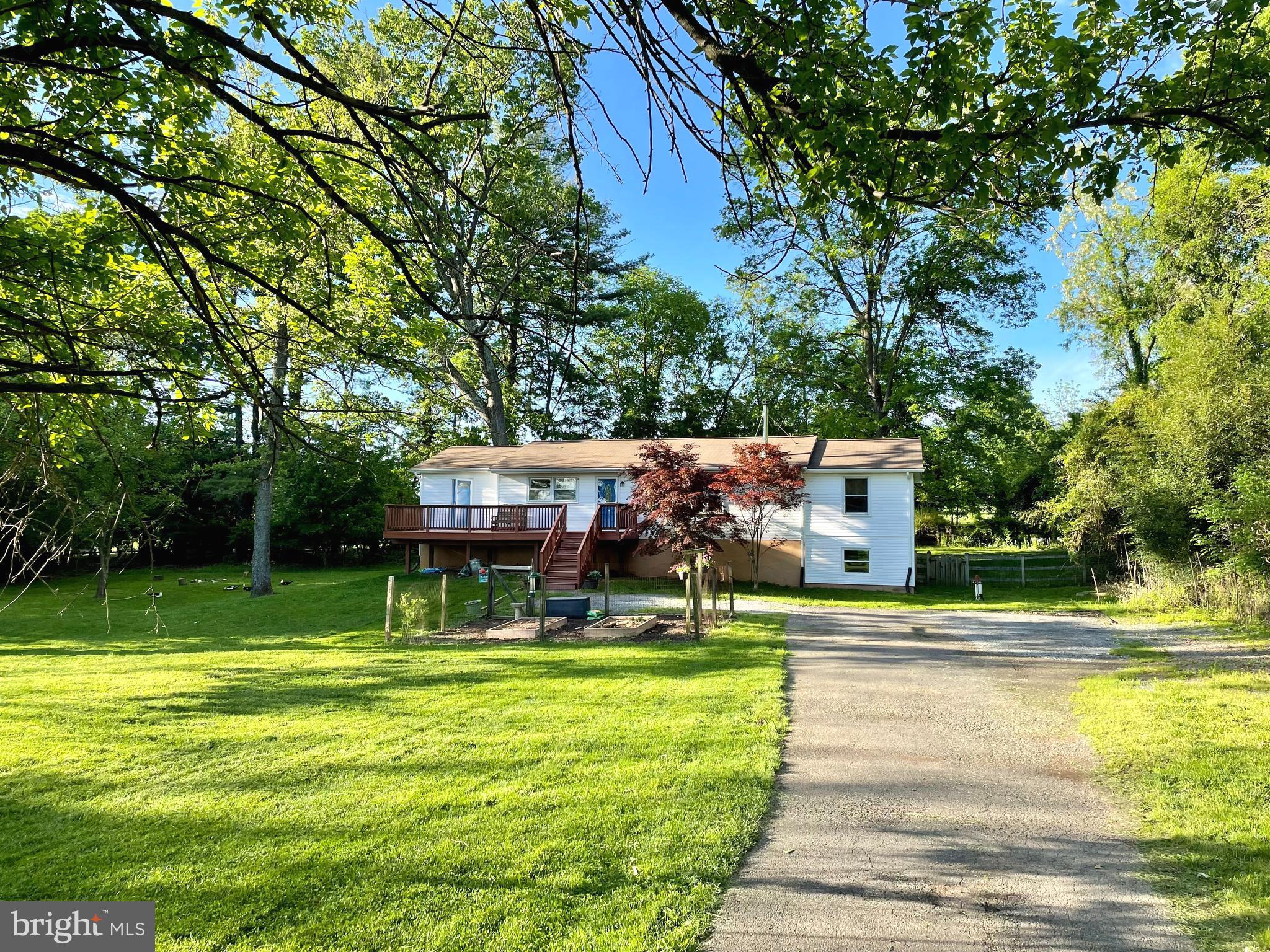 a view of pool with lawn chairs and large trees